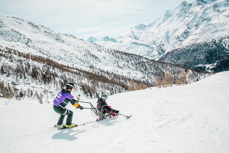 A sit-skier and a guide on a mountain slope