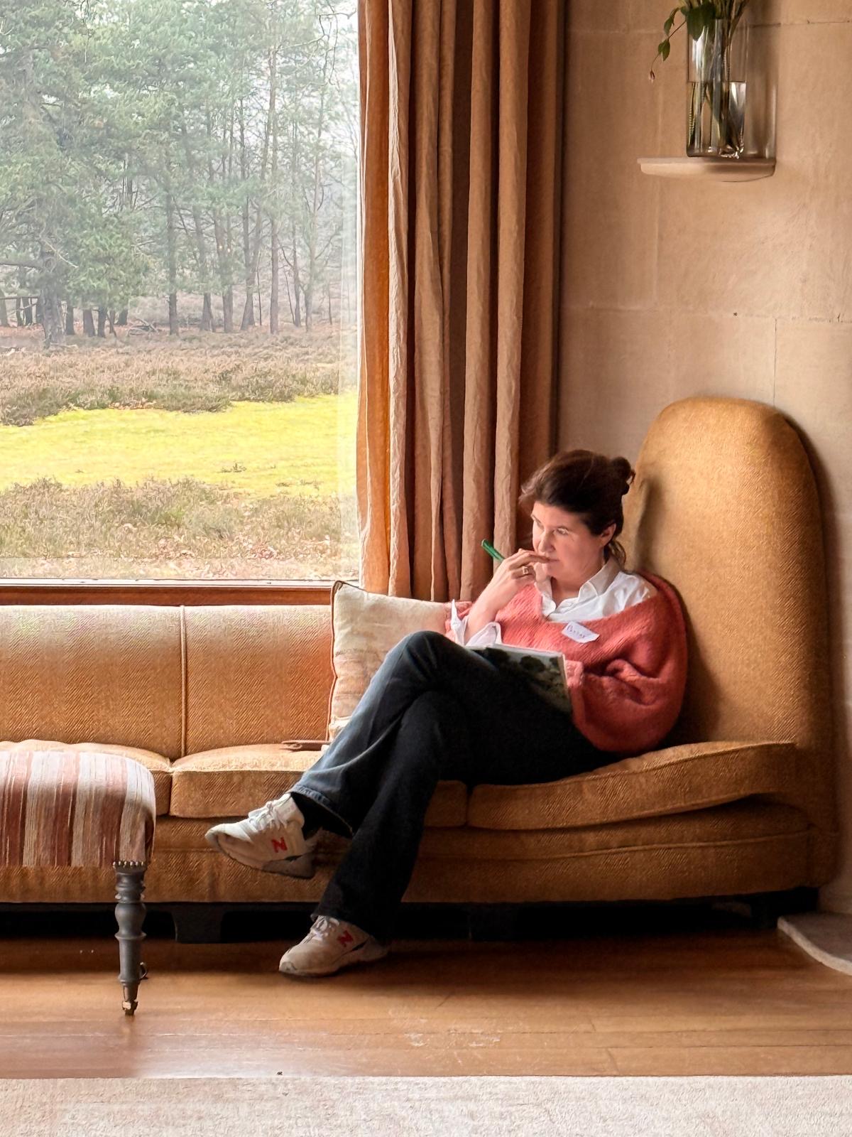 Esther de Kruijk sitting by a window with a notebook